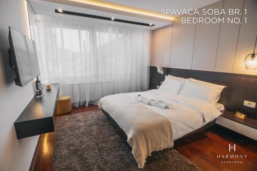 a bedroom with a bed with a television and a bed sidx sidx sidx at Harmony Apartmani Arandjelovac in Arandjelovac