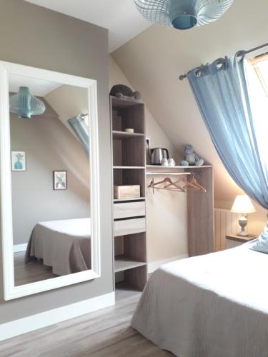 a bedroom with a mirror and a bed at Ferme du Rupalley in Isigny-sur-Mer