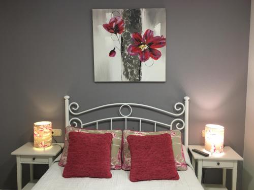 a bedroom with a bed with red pillows and two lamps at Hostal Restaurante Alarico in Allariz