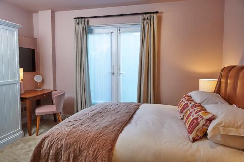 a bedroom with a bed with a desk and a window at Hotel Du Vin & Bistro Brighton in Brighton & Hove