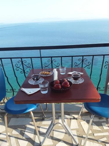 a table with bowls of fruit on a balcony at Odhisea Hotel Restaurant in Qeparo