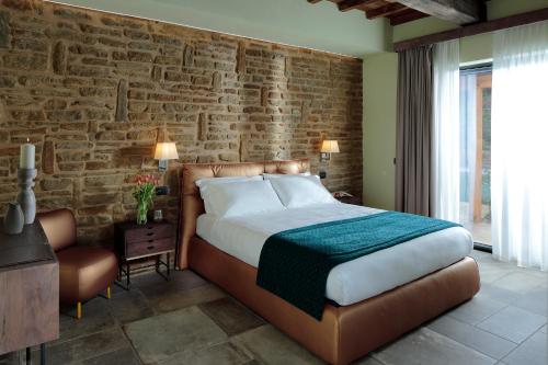 sypialnia z łóżkiem i ceglaną ścianą w obiekcie Perugia Vecchia Relais w mieście Deruta