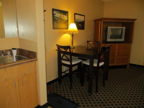a room with a table and chairs and a television at Athabasca Valley Inn & Suites in Hinton