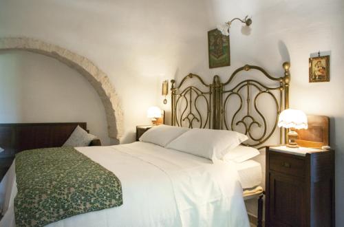 a bedroom with a large white bed and two lamps at Trulli sul vignale in Masseria Santalachicca in Martina Franca