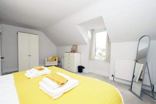 a bedroom with a yellow bed with towels on it at Ardentorrie Holiday Home in Inverness