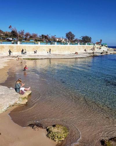 a group of people playing in the sand at the beach at Aurora in Marsaskala