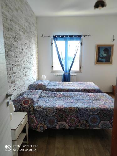 a bedroom with a bed and a window at La casa di Giulio - holiday home in Isola delle Femmine