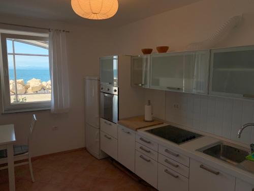 a kitchen with a view of the ocean from a window at Apartment Lanterna in Piran