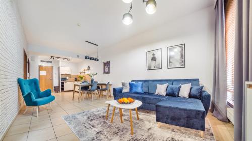 a living room with a blue couch and a table at Olympic Park I, Sun & Snow in Kołobrzeg