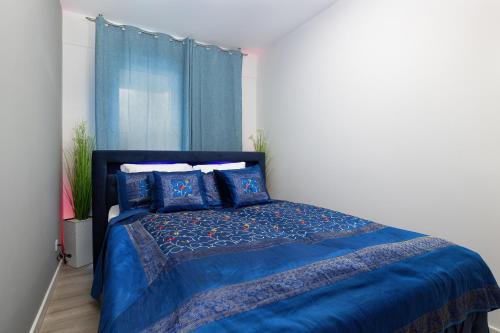a bedroom with a blue bed with blue sheets and a window at Platinium Apartment by Renters Prestige in Rewal