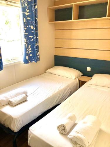 a room with two beds and a window at Camping Village Nice Garden in Ardea