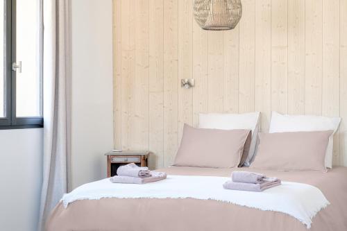 a bedroom with a bed with towels on it at L'Ostal Saint Hilaire d'Ozilhan - Bed & Breakfast - Spa in Saint-Hilaire-dʼOzilhan