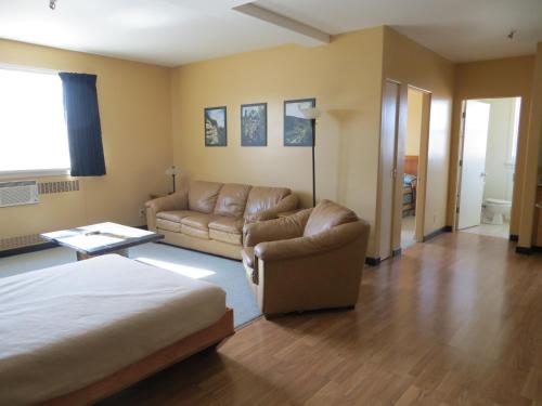 a living room with a bed and a couch at Athabasca Valley Inn & Suites in Hinton