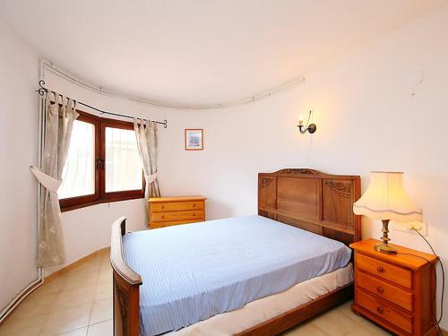 1 dormitorio con cama, lámpara y ventana en VILLA ALCAZAR, en Benitachell