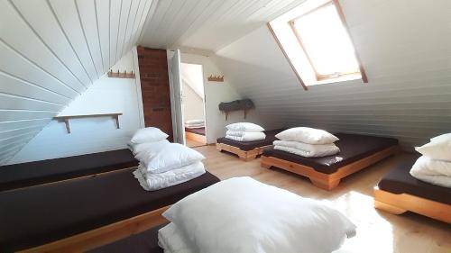 Zimmer im Dachgeschoss mit 3 Betten und einem Fenster in der Unterkunft Haudamäe Puhkemaja in Meelva