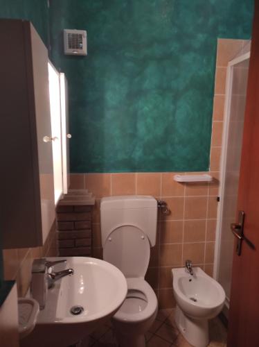 een badkamer met een wit toilet en een wastafel bij B&B Gli amici del tubarello in Roseto degli Abruzzi