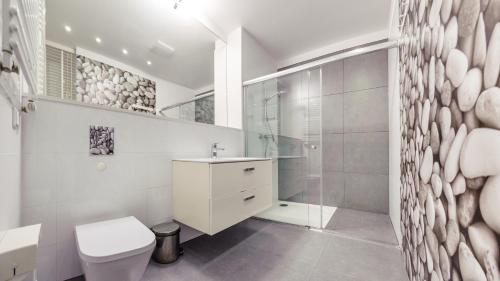 a white bathroom with a toilet and a shower at Olympic Park I, Sun & Snow in Kołobrzeg