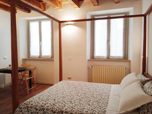 sypialnia z łóżkiem, stołem i oknami w obiekcie Moira Rooms w Bergamo