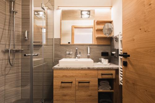 a bathroom with a sink and a shower at S'Kathrina - Appartements in Schattwald
