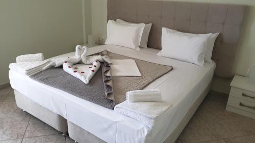 a bedroom with a white bed with towels on it at Vista Marina in Kalamata
