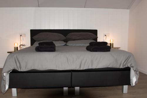 sypialnia z dużym łóżkiem z dwoma ręcznikami w obiekcie BnB Purmerland w mieście Purmerend