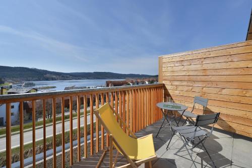 a balcony with a table and chairs and a river at Hotel Element in Lipno nad Vltavou