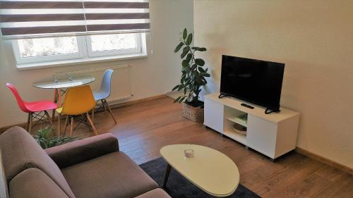 - un salon avec un canapé, une télévision et une table dans l'établissement Kod Lipe - Travnik, à Travnik