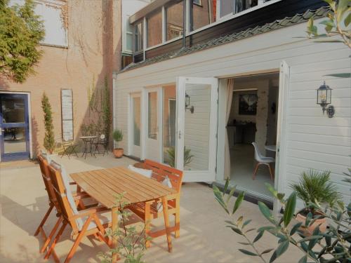 a patio with a wooden table and chairs at Spacious 70m2 apartment in city centre with lovely terrace in Alkmaar