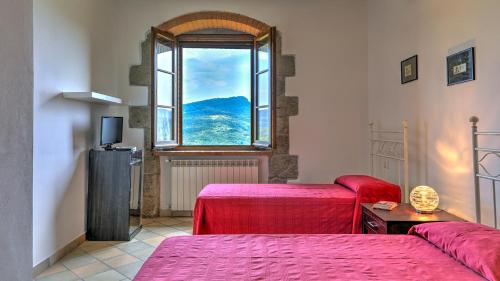 a room with two beds and a window at La Casa Di Elsa 6, Emma Villas in Santa Fiora