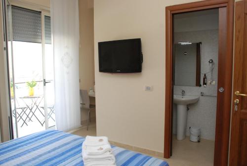 ein Schlafzimmer mit einem Bett und einem TV an der Wand in der Unterkunft B&B La Regina di Rimini in Rimini
