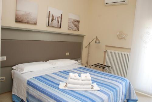 ein Schlafzimmer mit einem Bett mit Handtüchern darauf in der Unterkunft B&B La Regina di Rimini in Rimini