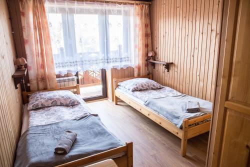 Tatrzańskie Kwatery tesisinde bir odada yatak veya yataklar