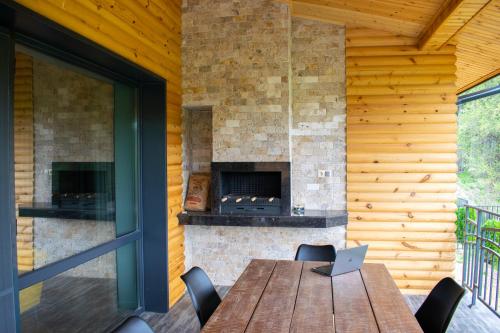 an outdoor patio with a wooden table and a fireplace at Villa Dea & Villa Ina - Villas & SPA Park in Velingrad in Velingrad
