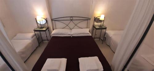 a small bedroom with two beds and two night stands at Wrh Trastevere in Rome
