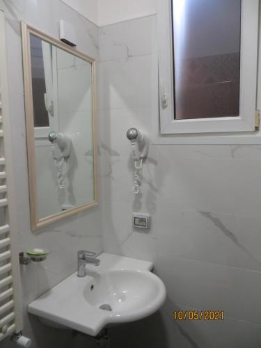 a white bathroom with a sink and a mirror at Hotel Silva in Rome
