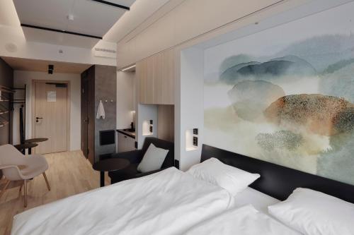 a bedroom with a bed and a painting on the wall at VALO Hotel & Work Helsinki in Helsinki
