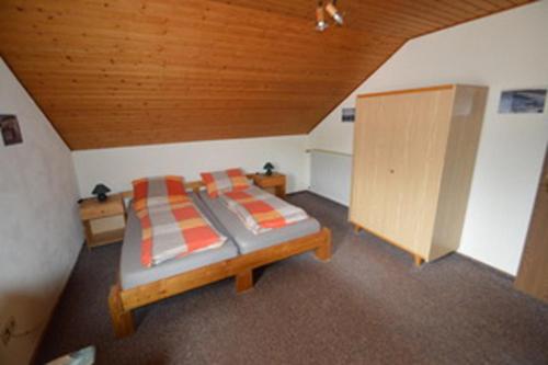 a bedroom with two beds and a wooden ceiling at Ferienwohnung Treutlein in Thüngersheim