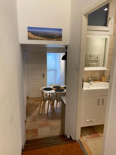 uma cozinha e sala de jantar com uma mesa e um lavatório em Maison de village au pays des lavandes à Valensole em Valensole