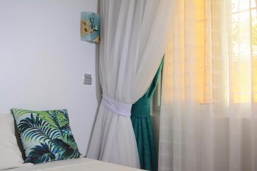 a woman is peeking out of a curtain at Golden Duranta Villas in Ukunda