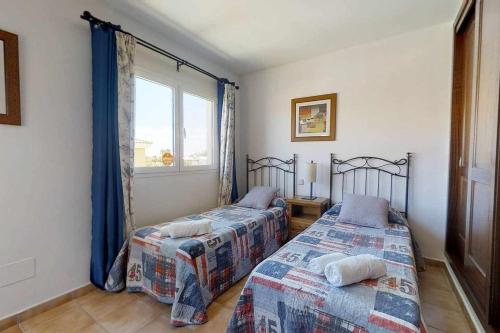 two beds in a room with a window at Anju villasVILLA MARGA VILLA AT 100 METERS FAR OF THE BEACH in Corralejo