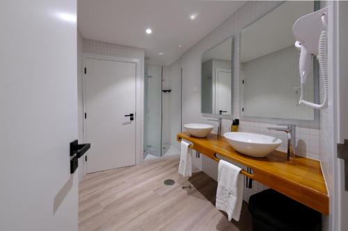 baño con 2 lavabos en una encimera de madera en Boa Nova Hostel, en Santa Cruz da Graciosa