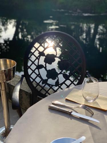 a table with a chair with a wine glass at Le Moulin du Roc in Brantôme