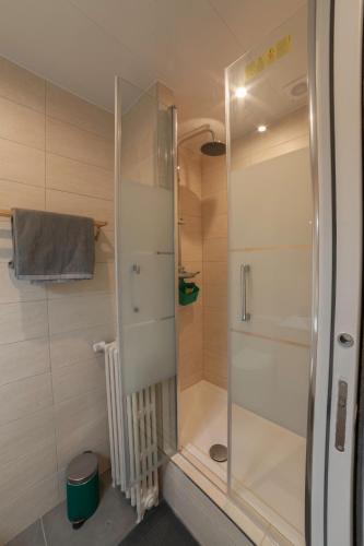 une douche avec une porte vitrée dans une salle de bain dans l'établissement PRESTIGELOC - Business & Confort - 3 Grandes Chambres, 2 SDB, Hyper Centre, à Orléans