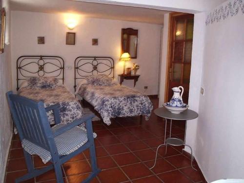 テヘーダにあるCasa Rural Las Cáscaras Tejeda Gran Canariaのベッドルーム1室(ベッド2台、テーブル、椅子付)