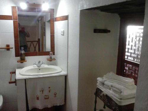 y baño con lavabo, espejo y toallas. en Casa Rural Las Cáscaras Tejeda Gran Canaria, en Tejeda