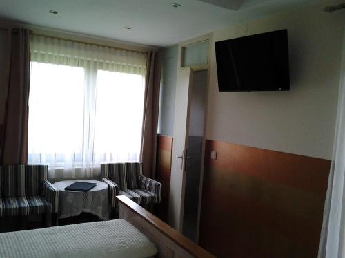 a hotel room with a table and a television on the wall at Lug ins Land Wachsenberg in Neusitz