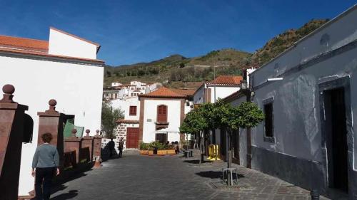 a person walking down a street in a town at Casa Rural Las Cáscaras Tejeda Gran Canaria in Tejeda