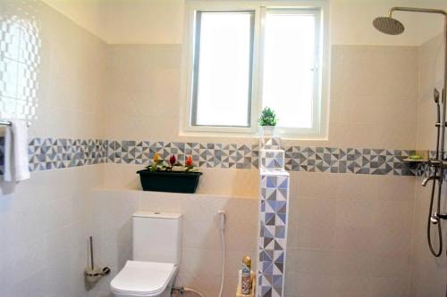a bathroom with a toilet and a window at Golden Duranta Villas in Ukunda