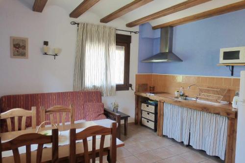 a living room with a couch and a table and a kitchen at Las Aliagas Apartamentos Rurales in Megina