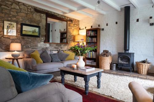 a living room with a couch and a wood stove at Little Underhill in Oswestry